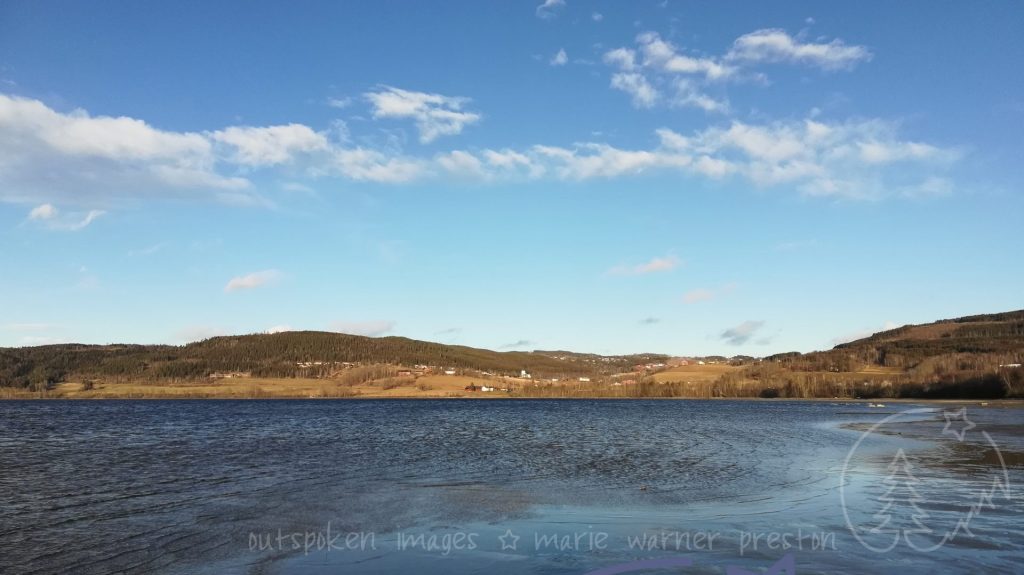 Randfjorden, Jevnaker, Norway. blue water, golden fields, blue sky with white clouds