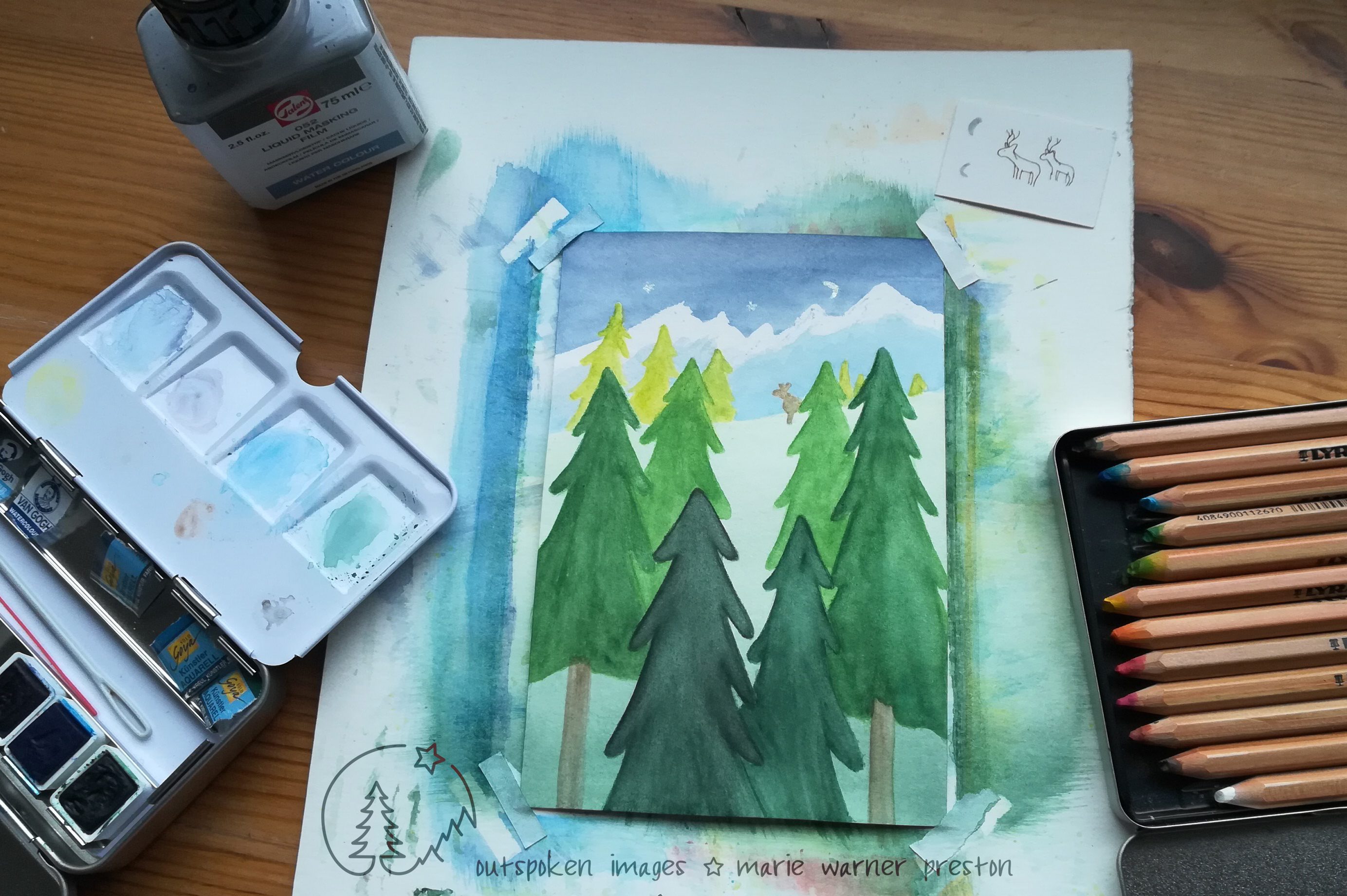 Watercolour painting: Green coniferous trees, brown moose, blue & white mountains, white moon sliver. Surrounded by paint, pencils, sketches ©2022 Marie Warner Preston / Outspoken Images